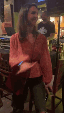 a woman in a red shirt is standing in a room