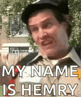 a man in a hat is making a funny face and says my name is henry