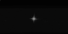 a white star is shining in the dark sky