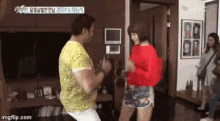 a man and a woman are dancing in a living room in front of a tv .