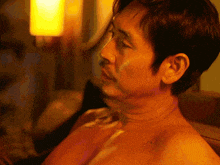 a man without a shirt is looking at something in the distance