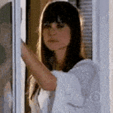 a woman is standing in a doorway looking out a window .