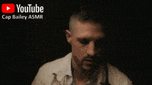 a man is talking on a cell phone with a youtube logo behind him