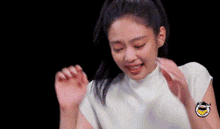 a woman in a white shirt is making a funny face with her hands in the air .