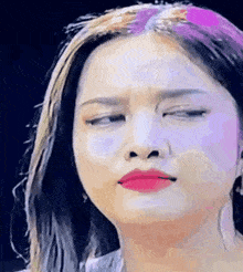 a close up of a woman 's face with her eyes closed and red lipstick on her lips .