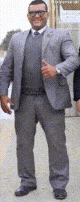 a man in a suit is giving a thumbs up sign