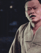 a man in a kimono making a funny face