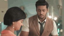 a man in a suit stands next to a woman