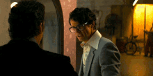 a man wearing glasses talks to another man