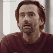 a man with a beard is wearing a maroon sweater with the hashtag @itsscottiesstark on the bottom right