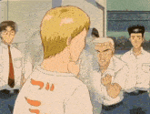 a group of people are standing around a man wearing a shirt that says " j " on the back
