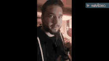a man with a beard is eating a hamburger in a room .