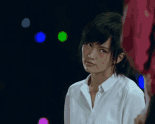a woman in a white shirt is looking at something