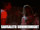 a man playing a guitar and a woman singing into a microphone with the words sausalito summernight on the bottom