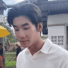 a close up of a man 's face with a yellow umbrella behind him