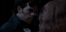 a man and a woman are looking at each other