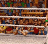 a pixelated image of a boxing ring with a crowd of people watching