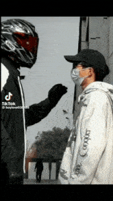 a man wearing a shoei helmet stands next to another man