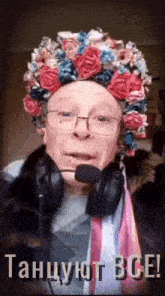 a man wearing headphones and a hat with flowers on it says " танцуют все "