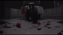 a woman is kneeling down in front of a table with blood on it