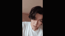 a young man wearing a white t-shirt is smiling and dancing