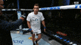 a man in a white ufc shirt is talking into a microphone