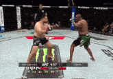 two men are fighting in a ufc ring with a monster energy can in the foreground