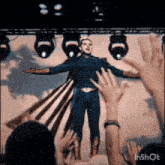 a man in a superhero costume is standing on a stage in front of a crowd