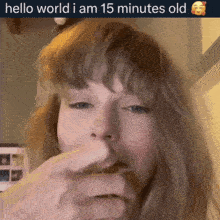 a woman eating something with the words hello world i am 15 minutes old on the bottom