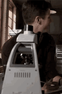 a man is looking through a microscope in a laboratory .