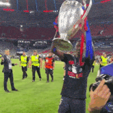 a man holding a trophy that says champions league