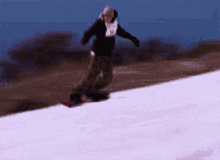 a snowboarder is riding down a snowy slope with a red flag in the background