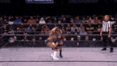 a wrestling match is going on in front of a crowd that is wearing a mask