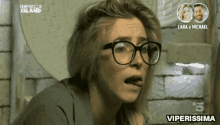 a woman wearing glasses is making a funny face