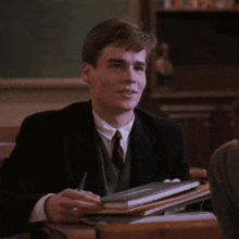 a young man in a suit and tie is pointing up