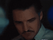 a close up of a man 's face with a mustache and beard .