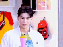 a man in a white jacket is holding a cup with a s on it