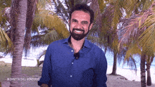 a man in a blue shirt stands in front of palm trees with the words in diretta dall honduras below him