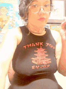 a woman wearing glasses and a tank top that says " thank you enjoy "