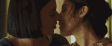 a close up of two women kissing with the letter j on the bottom