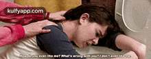 a woman is laying on the floor with a man putting his hand on her shoulder