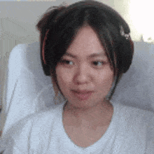 a woman wearing headphones is sitting in a chair and smiling .