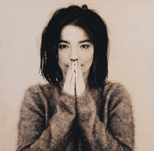 a black and white photo of a woman with her hands covering her mouth
