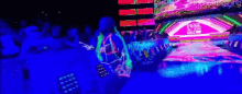 a person in a glow in the dark outfit is standing in front of a crowd of people .
