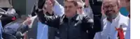 a group of men are standing next to each other with their arms in the air