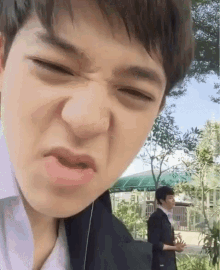 a close up of a person making a funny face with their eyes closed