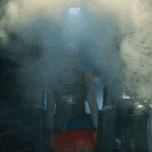 a woman with a snake on her face is standing in a dark room
