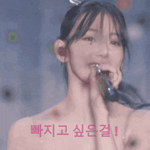 a woman with a bow in her hair is holding a microphone in her hand with a foreign language written above her