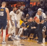a group of basketball players are standing on a court with a referee .