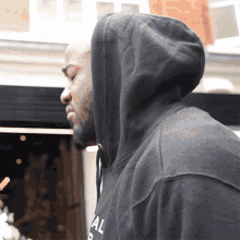 a man wearing a black hoodie with the letter b on the front